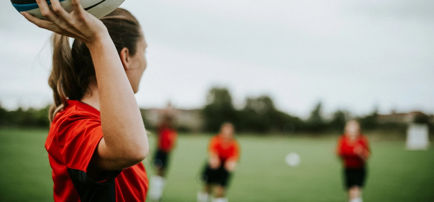 Rugby game with woman throwing ball