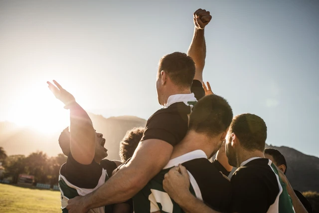 Group of rugby players cheering during match
