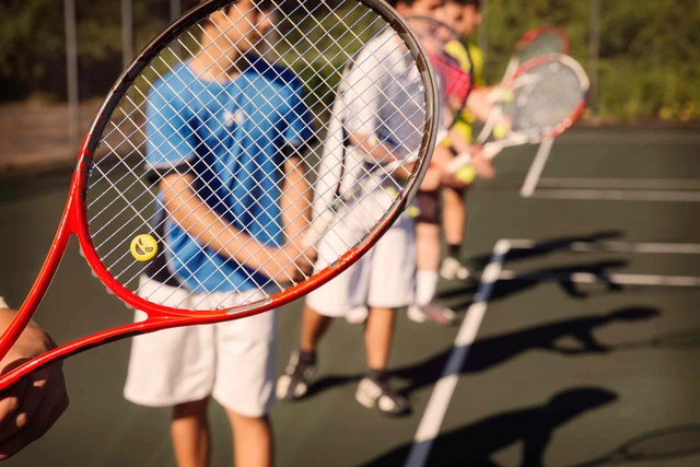 Group of juniors holding up tennis racquet
