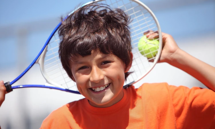 Boy with tennis racquet and ball